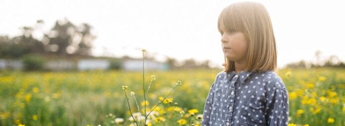 Young_girl_standing_in_field_of_flowers_looki.width-1000