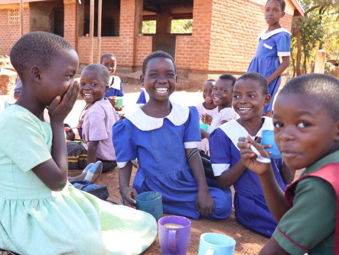 Children smiling after receiving Mary's Meals in Malawi
